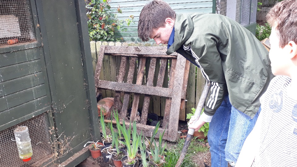 Jamie, a Young Volunteer working for Porridge and Rice, helps to prepare soil for sowing seeds to sell to raise money for Porridge and Rice